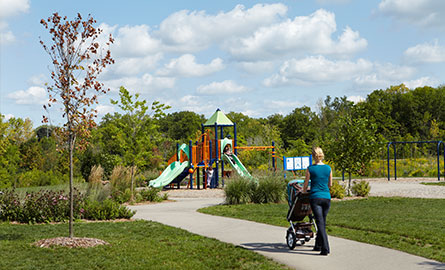 Woman in park pushing a stroller