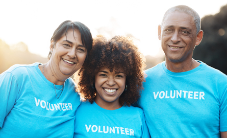 Group of volunteers smiling in matching shirts